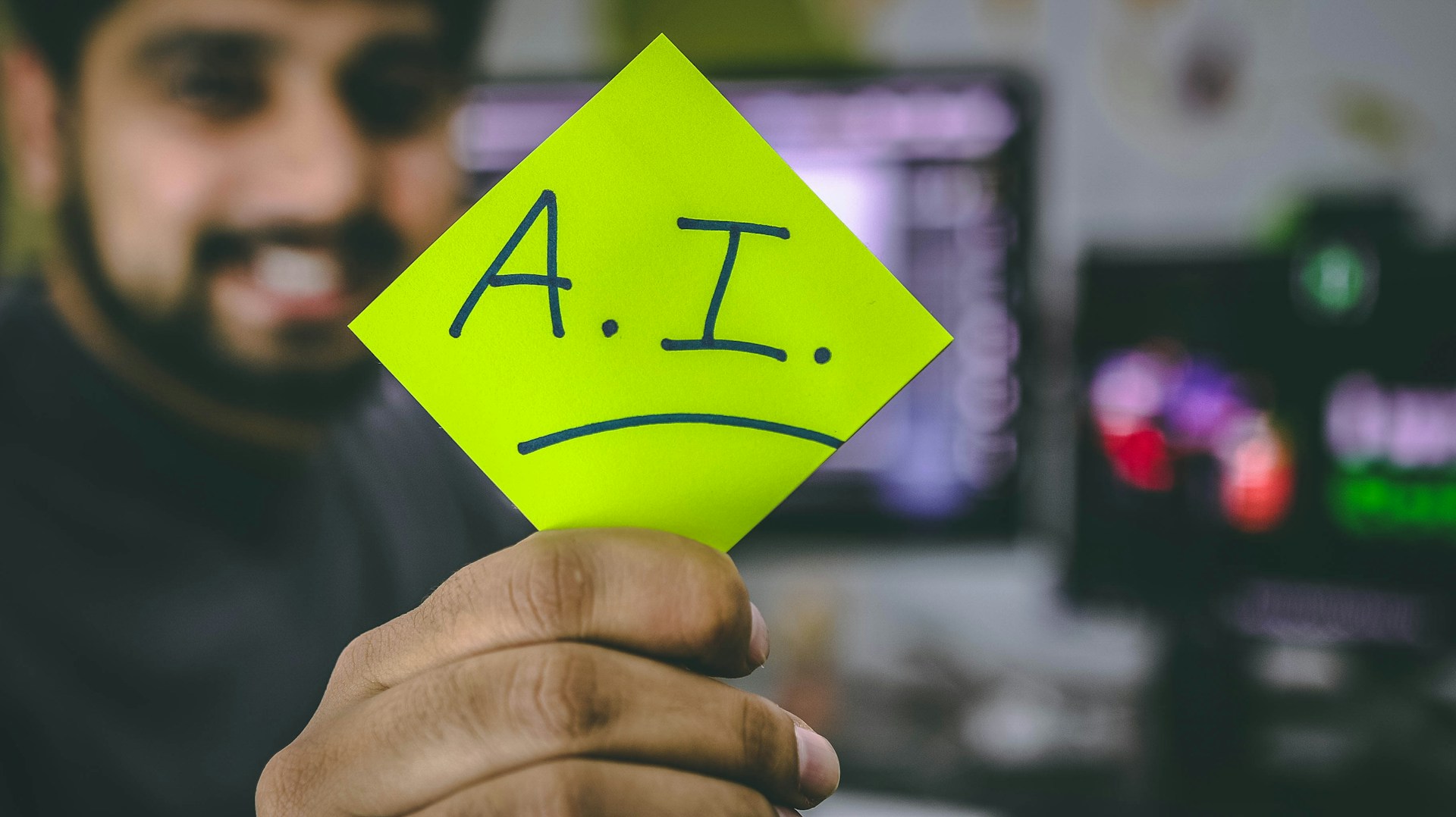 Man holding a sticky note with "A.I." written on it.